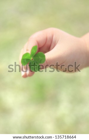 Similar – young hand in turquoise jacket holds four-leaf green clover