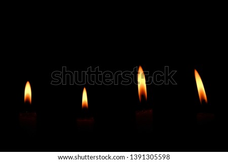 Four light flame candle burning brightly on black background