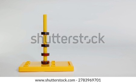Four magnetic rings float on a yellow plastic stand against a clean white background.