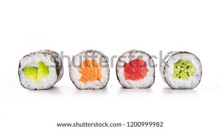 Four maki rolls in a row with salmon, avocado, tuna and cucumber isolated on white background. Fresh hosomaki pieces with rice and nori. Closeup of delicious japanese food with sushi roll.
