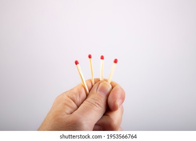 four match sticks in hand  one is shorter  as symbol for to lose out