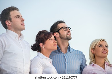 Four Modern Business People Looking Up