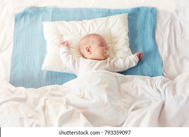 Four month old baby sleeping on blue blanket - Powered by Shutterstock