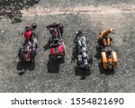 four motorcycles parked side by side on a gravel surface