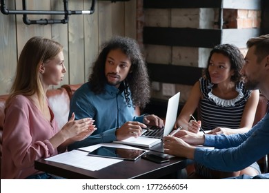 Four multi ethnic young group of employees during lunch in cafe working together on common project, corporate task, preparing for conference activity, listen team leader. Mentoring, teamwork concept - Shutterstock ID 1772666054