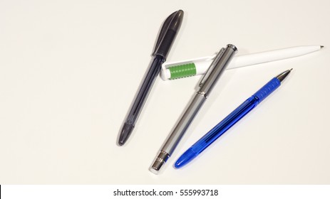 Four multi-colored pens on a white background