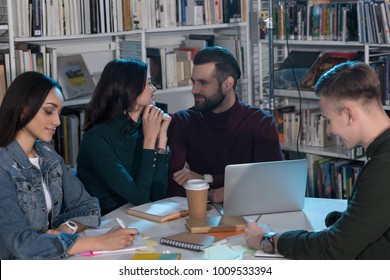 four multiethnic friends studying in library in evening - Shutterstock ID 1009533394