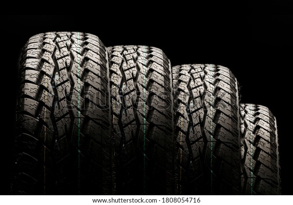 four\
off-road tires close-up on a black\
background.