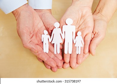 Four Old Hands Holding A Cutout Paper Family