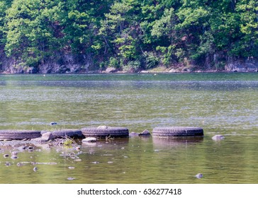 Four Old Tires Lineup Next To Each Other To Form A Foot Bridge At The Bank Of A River In South Korea