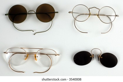 Four pairs of old glasses on white background.