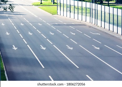 Four paved lanes with traffic arrows directing traffic in various directions, dedicated bus lane. - Powered by Shutterstock