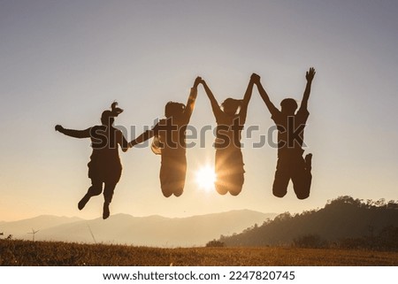 Four people jumping on mountain sunset sky background. 