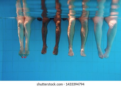 four people legs underwater in the swimming pool. Friends. Party. Summer. Vacation and sport concept. - Powered by Shutterstock