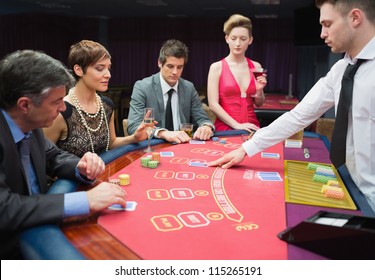 Four People Playing Poker In Casino