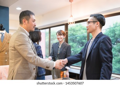 Four People Shaking Hands With A Smile