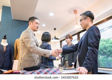 Four People Shaking Hands With A Smile