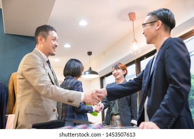 Four People Shaking Hands With A Smile