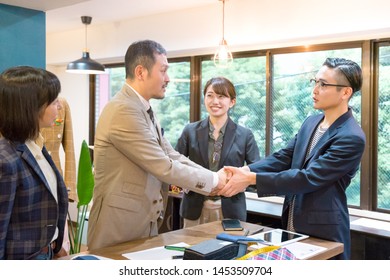 Four People Shaking Hands With A Smile