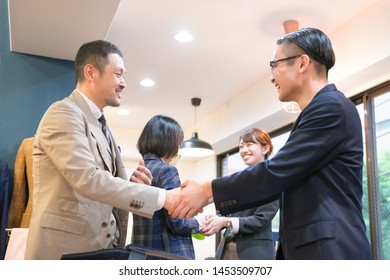 Four People Shaking Hands With A Smile