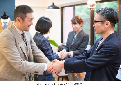 Four People Shaking Hands With A Smile