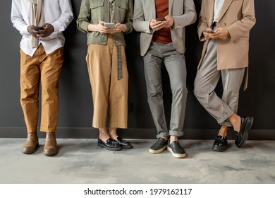 Four people in smart casualwear scrolling in smartphones - Shutterstock ID 1979162117