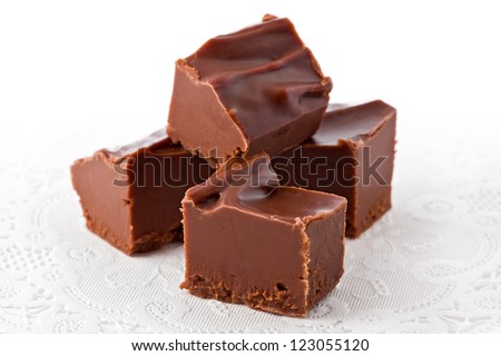 Four pieces of chocolate fudge on a white doily.