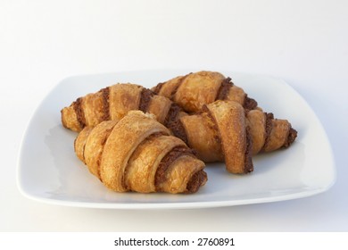 Four pieces of freshly toasted butter croissant served on white plate