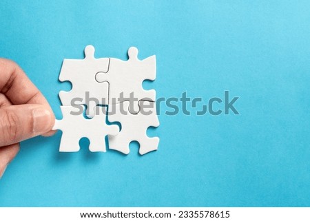 Four pieces of plain white jigsaw puzzle isolated on blue background for business conceptual.