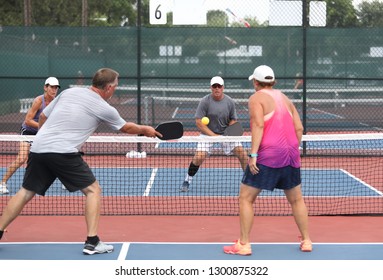 Four Players Compete In The Mixed Doubles Division Of A Pickleball Tournament