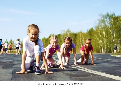 four pre-teen girls starting to run on track - Powered by Shutterstock