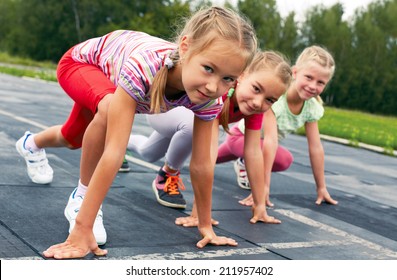 four pre-teen girls starting to run on track - Powered by Shutterstock