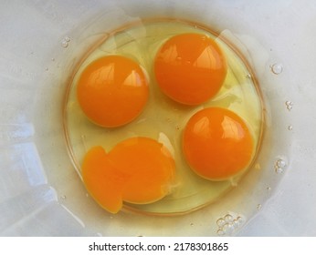 Four Raw Chicken Eggs Broken Into A Transparent Glass Bowl Standing On A White Table Top View, Food Protein Ingredients Of Animal Origin, Homemade Breakfast Products