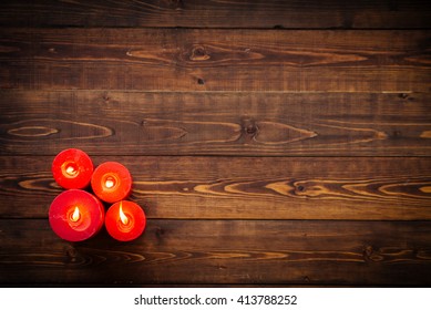 Four Red Candles On Brown Wooden Table, Top View