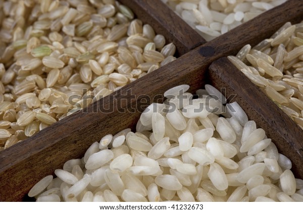 four rice grains in a vintage wood drawer with\
dividers - focus on white arborio rice used for traditional Italian\
meal, risotto