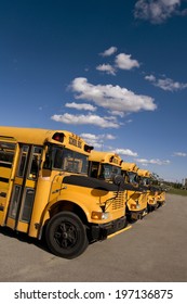 Four School Buses Lined Up In A Row.