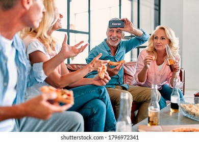 Four senior friends having fun at home.  Group of old friends playing game guess who in modern apartment. Two handsome mature men and two attractive women spending time together indoors. - Powered by Shutterstock