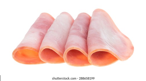 Four Slices Of Honey Ham Deli Meat Folded On A White Background.