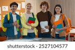 Four smiling happy friendly students friends girls females Caucasian boys guys males pupils together looking at camera smile holding books in school university college academy class studying learning