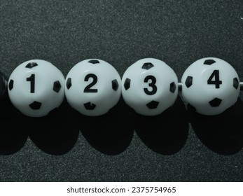 Four soccer balls in a row, each with a number. - Powered by Shutterstock