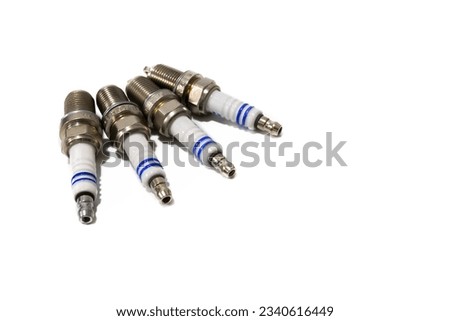 Four spark plugs isolated on a white background.The spark plug is the element that produces the ignition of the mixture of fuel and oxygen in the cylinders, by means of a spark, in a combustion engine