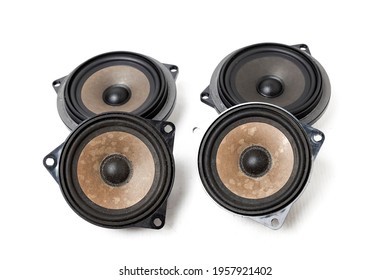 Four speakers of an acoustic system - an audio for playing music in a car interior on a white isolated background in a photo studio. Spare parts for auto repair in a workshop or for sale for tuning