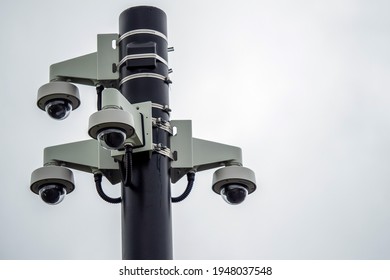 Four Spherical CCTV Cameras Fixed On A Black Metal Pole. Security And Safety Concept.