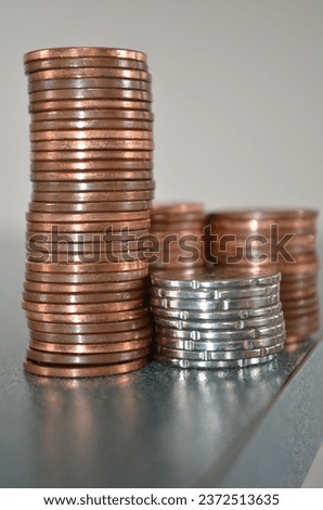 Four Stacks of NZ 10c and 20c Coins, includes a tall copper stack and smaller silver stack.
