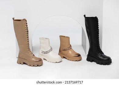 Four Stylish Leather Boots In A Single Copy On The Podium In The Form Of Steps In The Studio On A White Background