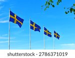 Four Swedish flags flutter against the sky.National Day of Sweden.