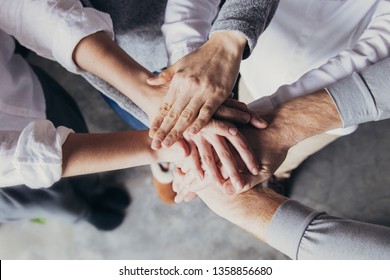 Four team members expressing togetherness and integrity. Closeup of stack of hands. Team concept