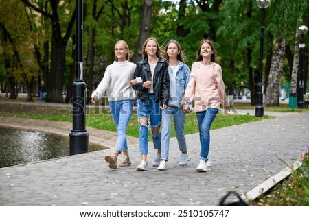 Four teenage girls walking in the park