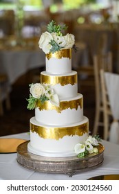 Four Tier Wedding Cake With Gold Leaf And Fresh Flowers