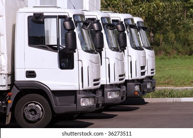 four trucks of a transporting company in a row